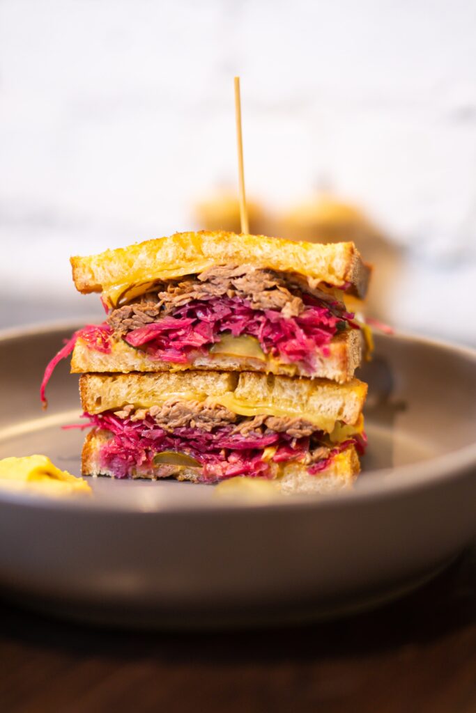 Reuben sandwich cut in half to see the filling. 